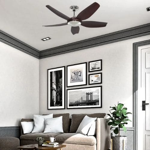 Ventilateur de plafond silencieux moderne avec trois pales brun foncé dans un salon élégant, cadre photo noir et blanc et plante verte.