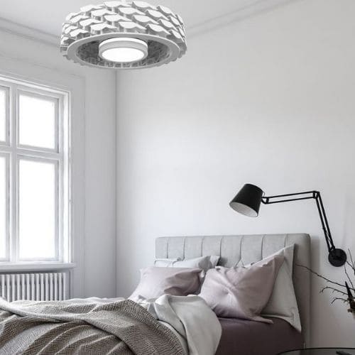 Lampe suspendue moderne au plafond au-dessus d’un lit dans une chambre lumineuse.