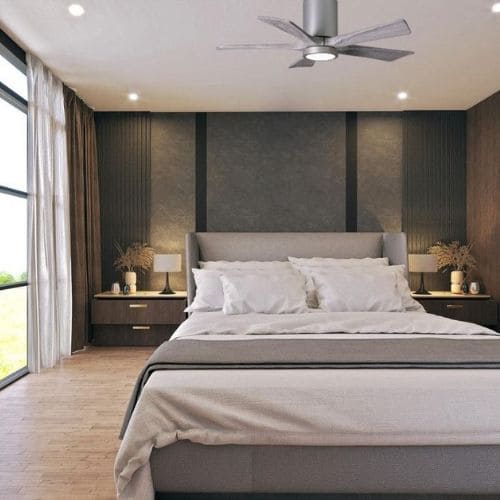 Ventilateur plafond petit diamètre moderne au plafond d'une chambre spacieuse; lit king size, tables de chevet et éclairage doux.
