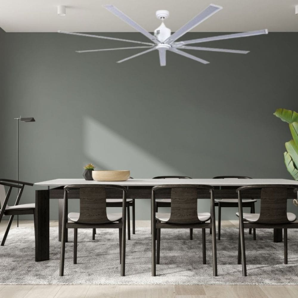 Ventilateur économe d'énergie au-dessus d'une grande table de salle à manger, cadre moderne avec mur gris, chaises en bois et lampadaire, intérieur élégant.