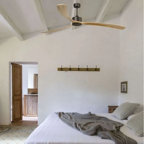 Ventilateur de plafond avec pales en bois dans une chambre lumineuse.